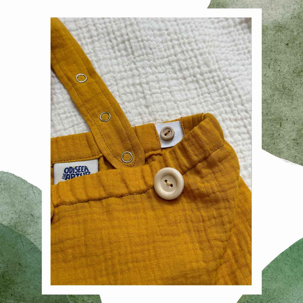 Detaliu pantalon culoarea nisipului cu bretele din muselina moale de bumbac, pentru bebelusi si copii, pentru botez, aniversari, sedinte foto. Odiseea lui Artur